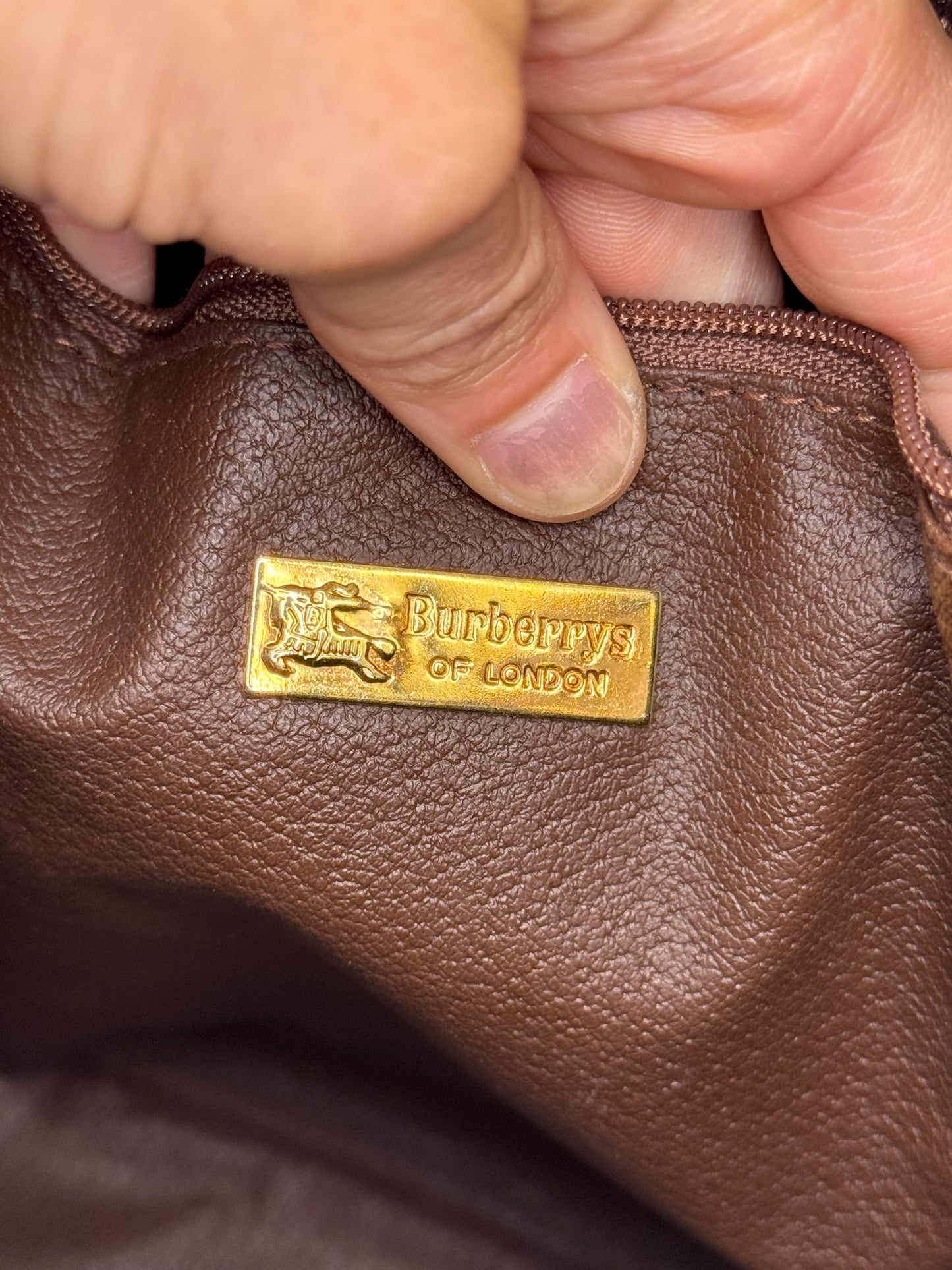 Dettaglio interno della borsa Borse Vintage Burberrys con placca metallica dorata e logo del cavaliere equestre