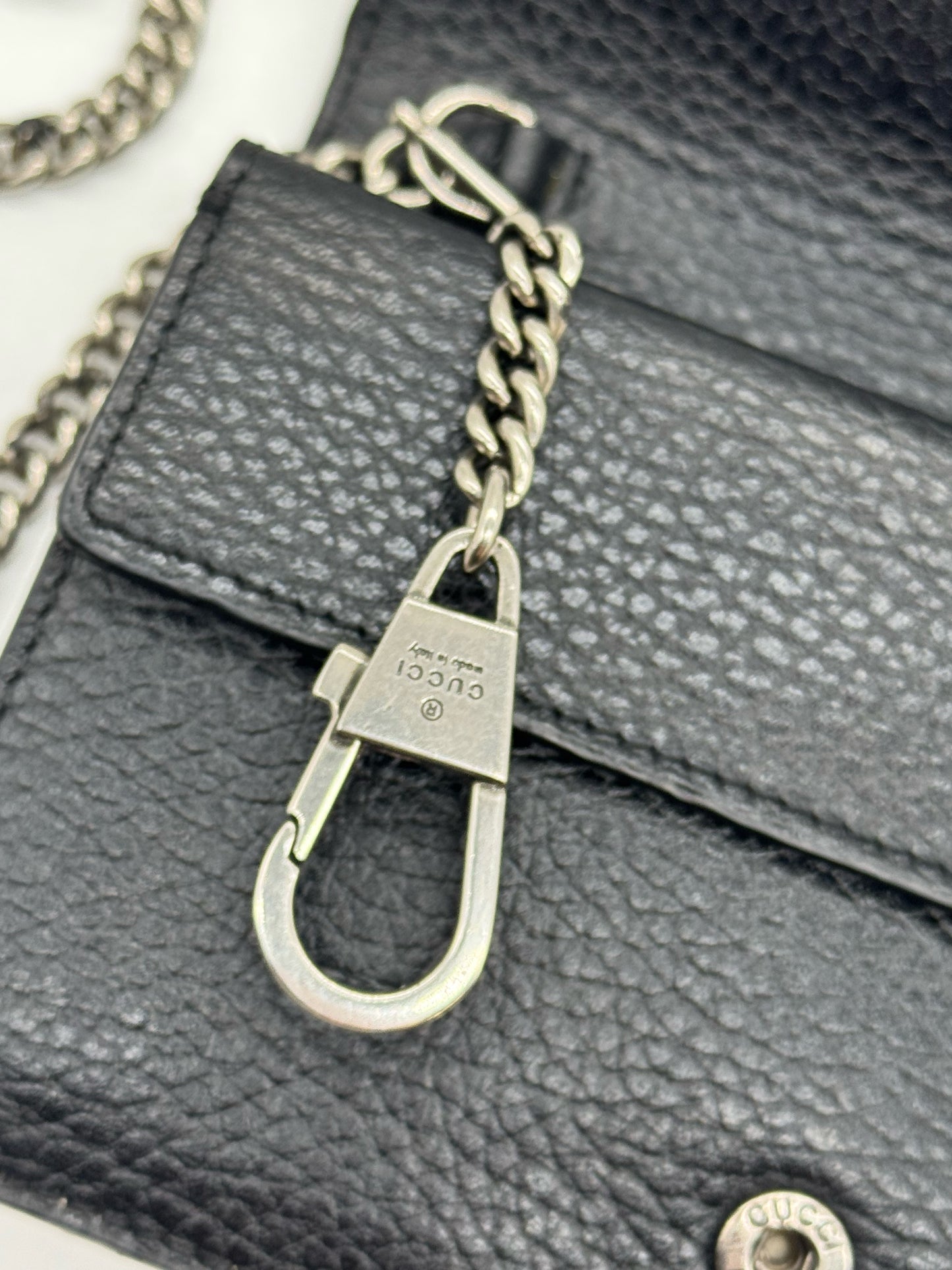 Dettaglio del moschettone in metallo argentato con logo Gucci su borsa Borse Vintage in pelle nera martellata