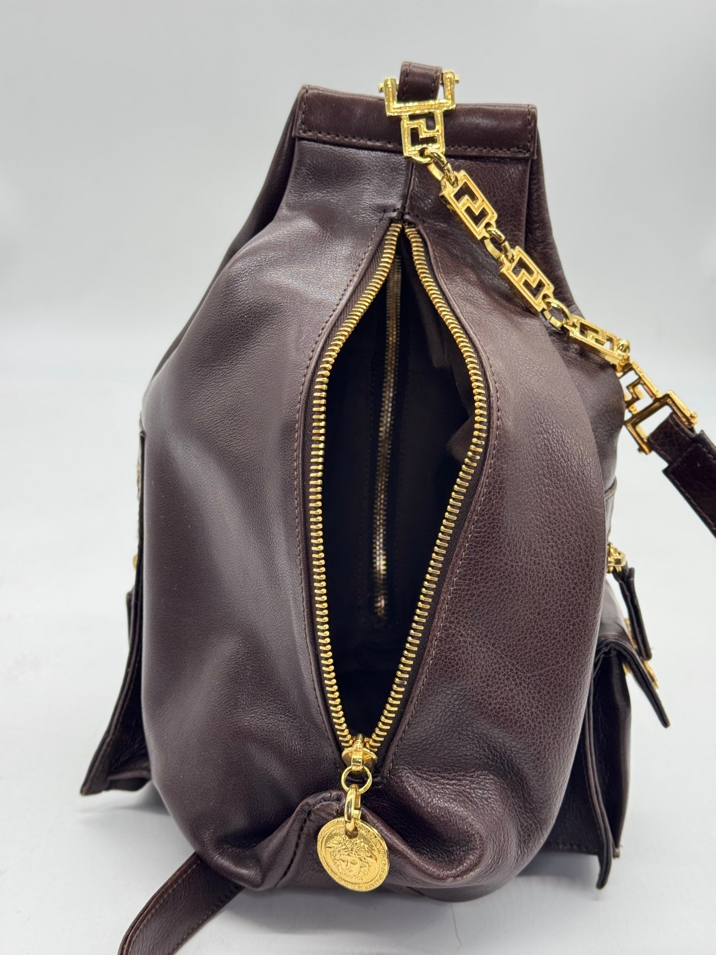 Zaino Borse Vintage Gianni Versace in pelle marrone scuro con dettagli metallici dorati e ciondolo Medusa.