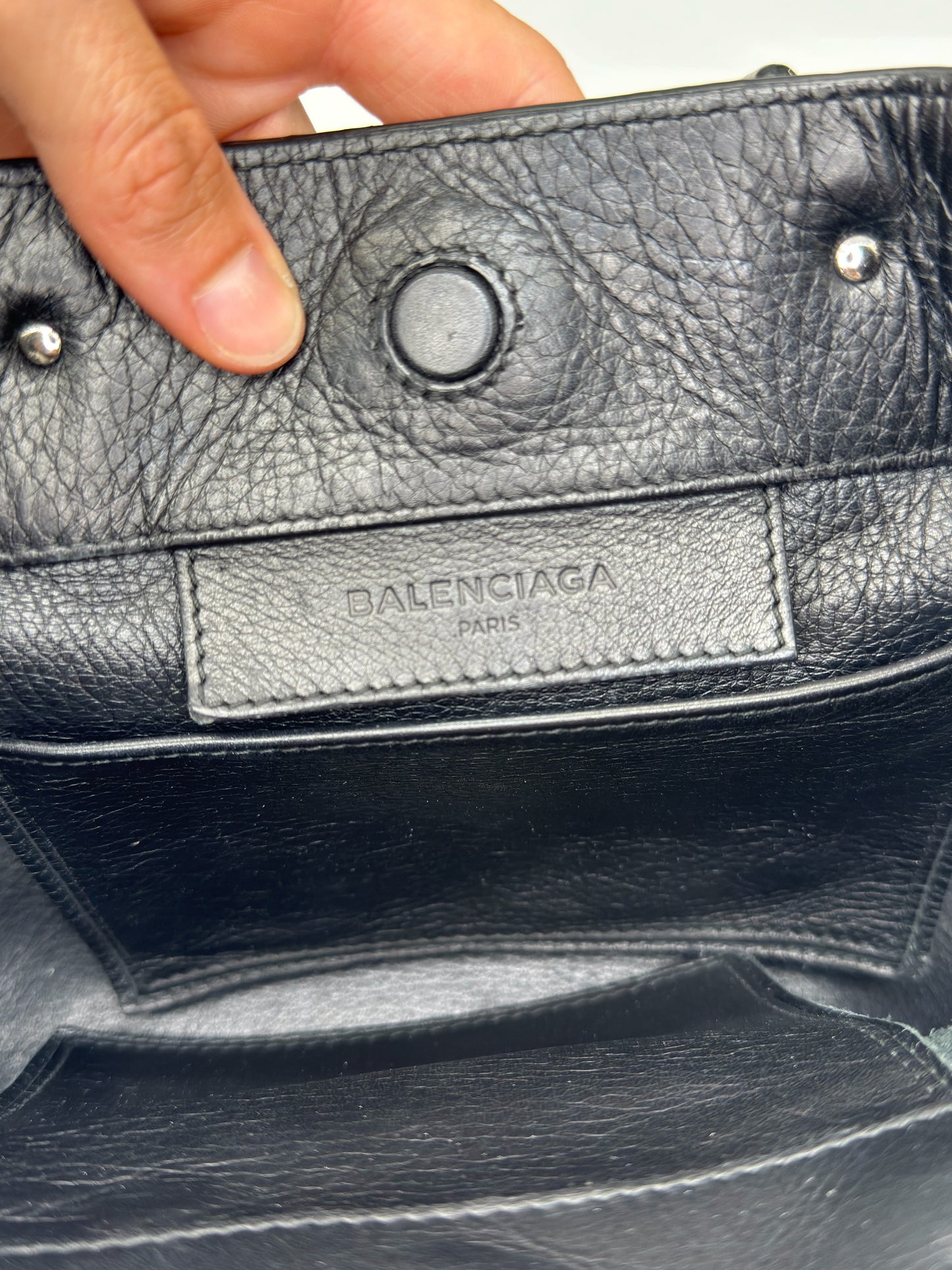 Dettaglio interno della borsa Borse Vintage Balenciaga in pelle martellata nera con logo impresso e chiusura magnetica