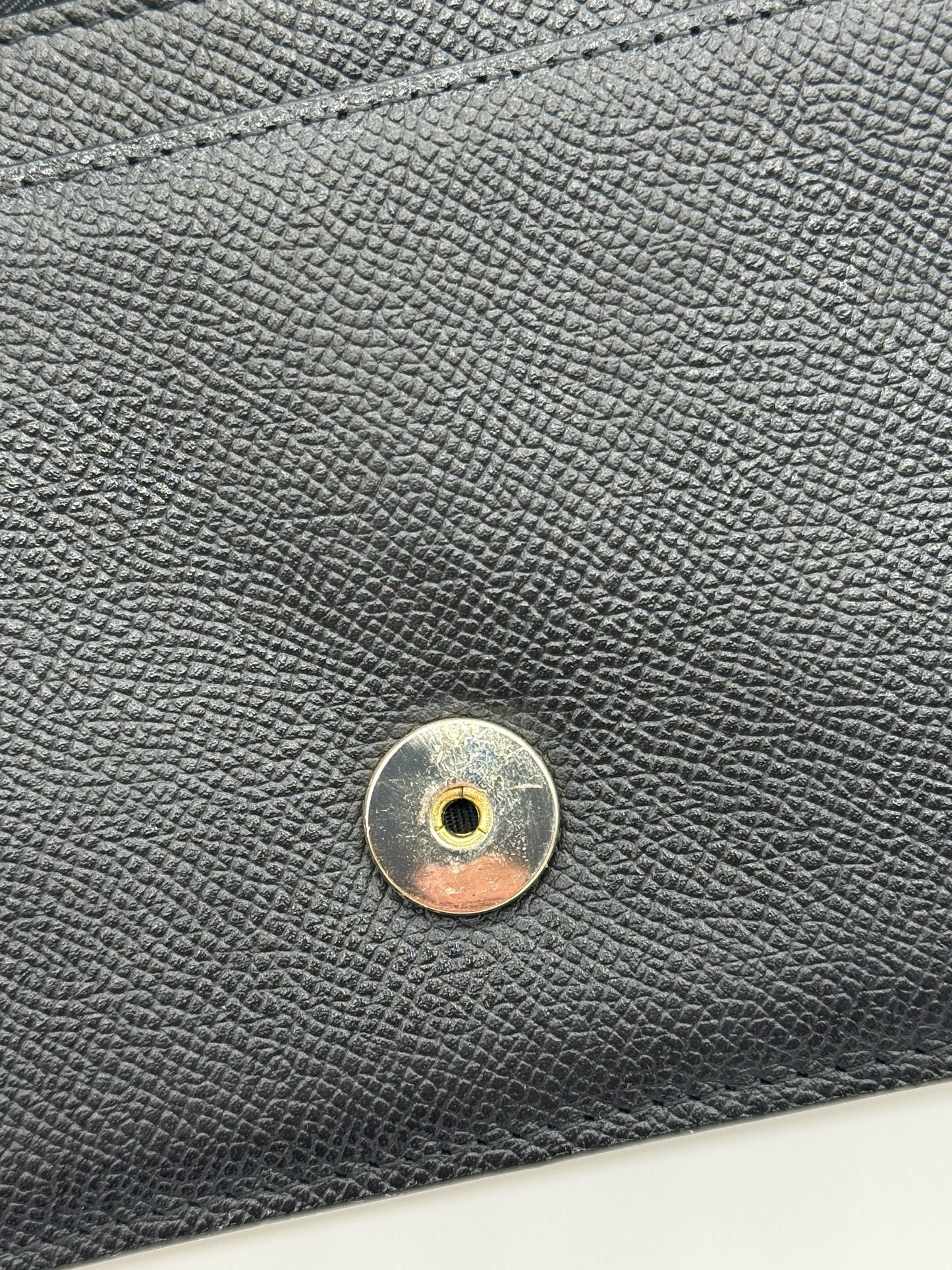 Dettaglio della chiusura magnetica dorata su pelle nera granulata della borsa Borse Vintage Christian Dior