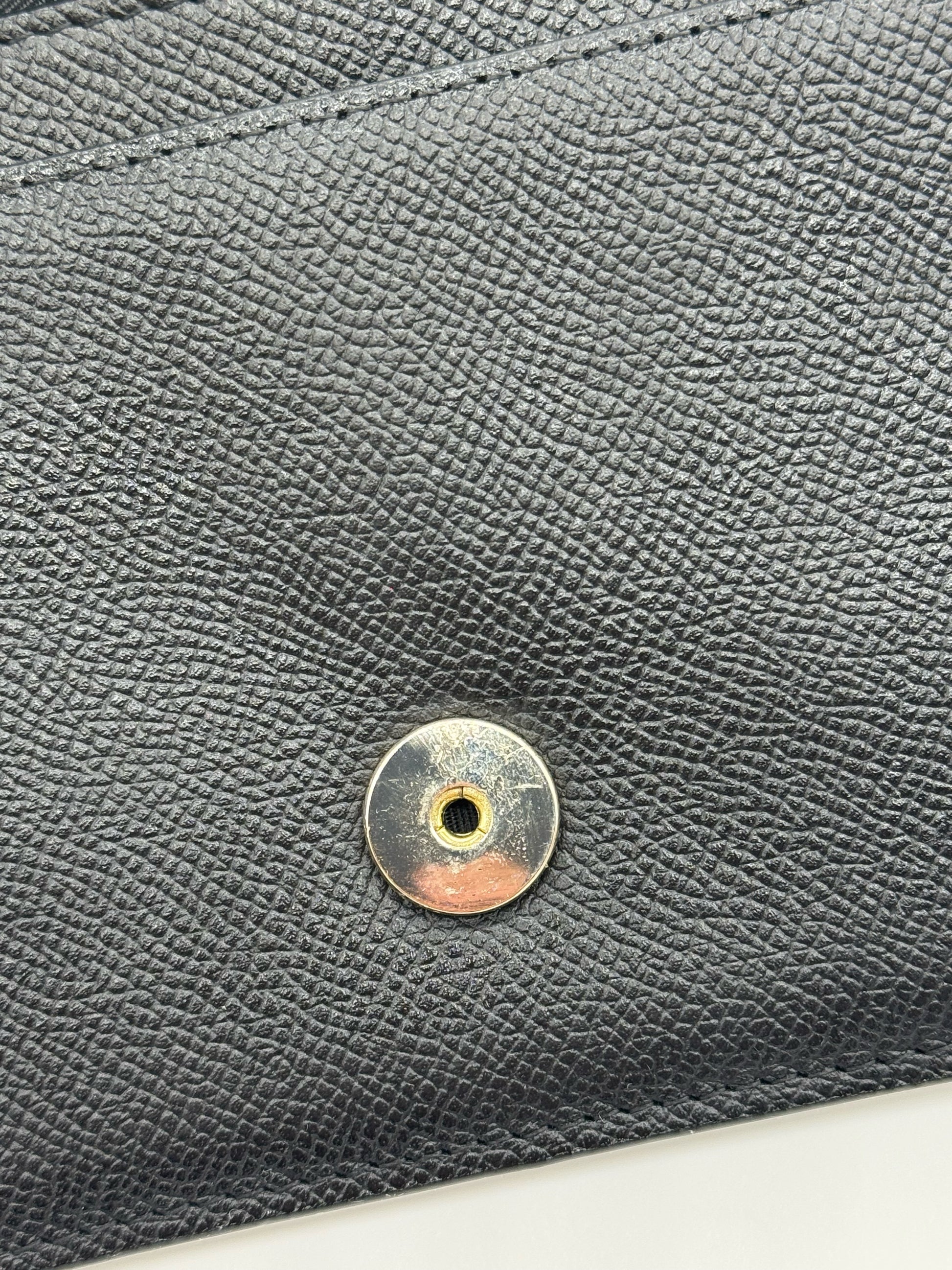 Dettaglio della chiusura magnetica dorata su pelle nera granulata della borsa Borse Vintage Christian Dior