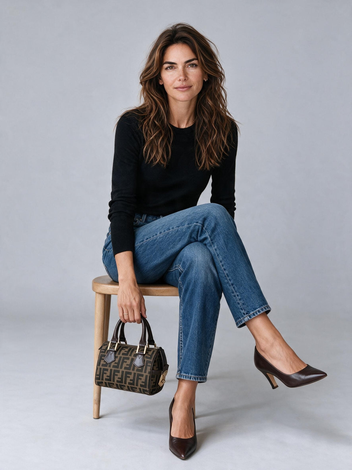 Modella seduta con borsa a mano Fendi Vintage Borse Vintage in tela monogrammata marrone e dettagli in pelle