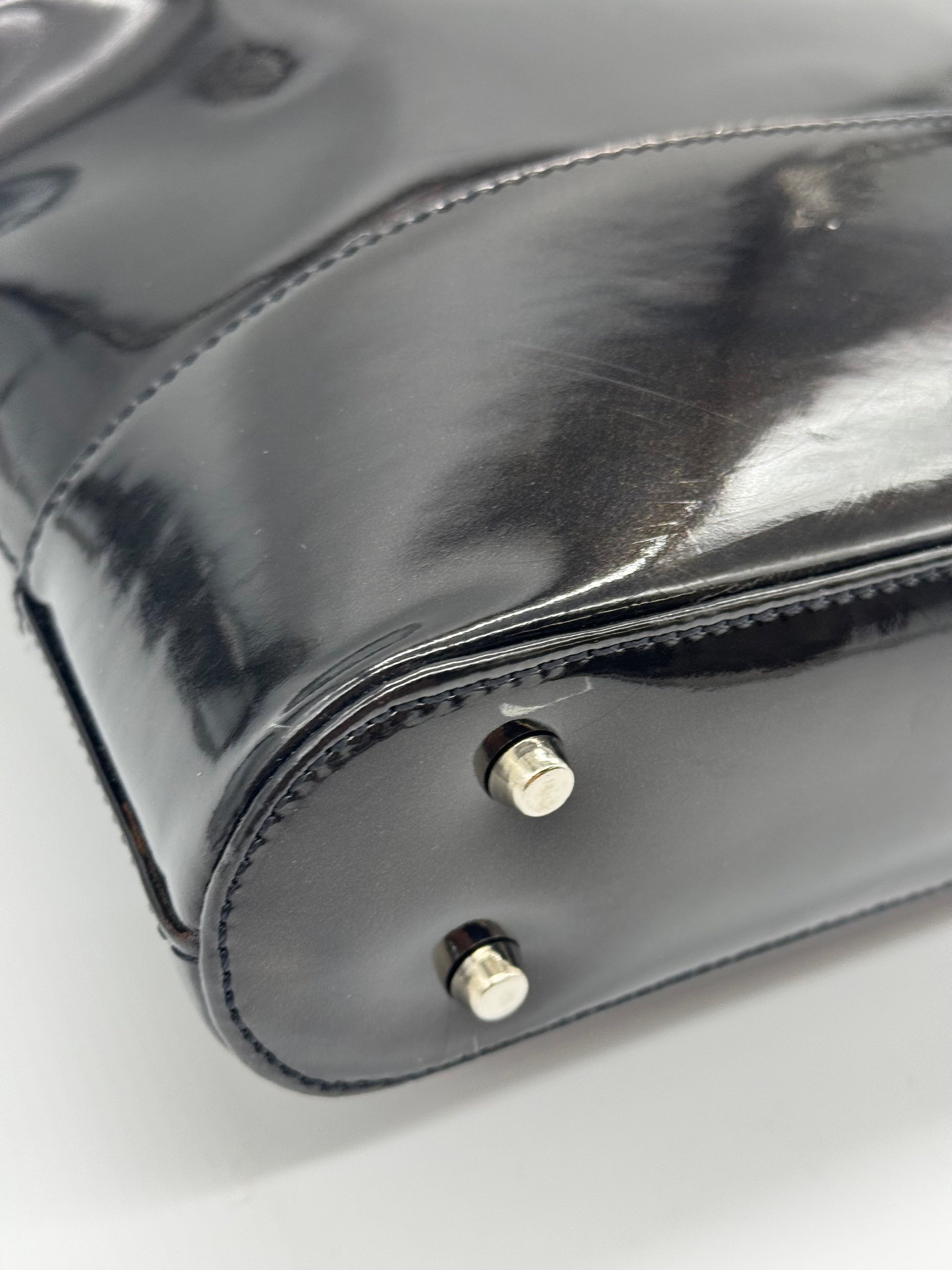 Dettaglio della base in pelle verniciata nera della borsa a mano Borse Vintage Gianni Versace con piedini metallici
