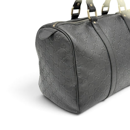 Borsa a mano Borse Vintage Gucci in pelle nera con motivo GG impresso, dettagli dorati e chiusura superiore con zip.
