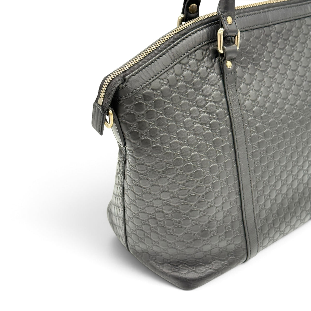 Borsa a spalla Borse Vintage Gucci in pelle nera con motivo GG impresso, chiusura con zip e dettagli dorati.