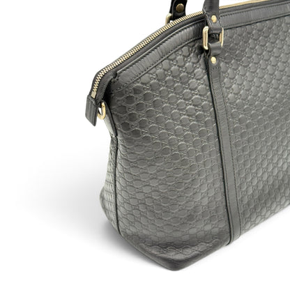 Borsa a spalla Borse Vintage Gucci in pelle nera con motivo GG impresso, chiusura con zip e dettagli dorati.