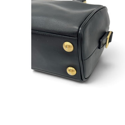 Dettaglio del fondo di una borsa a mano Borse Vintage in pelle nera con piedini protettivi in metallo dorato.