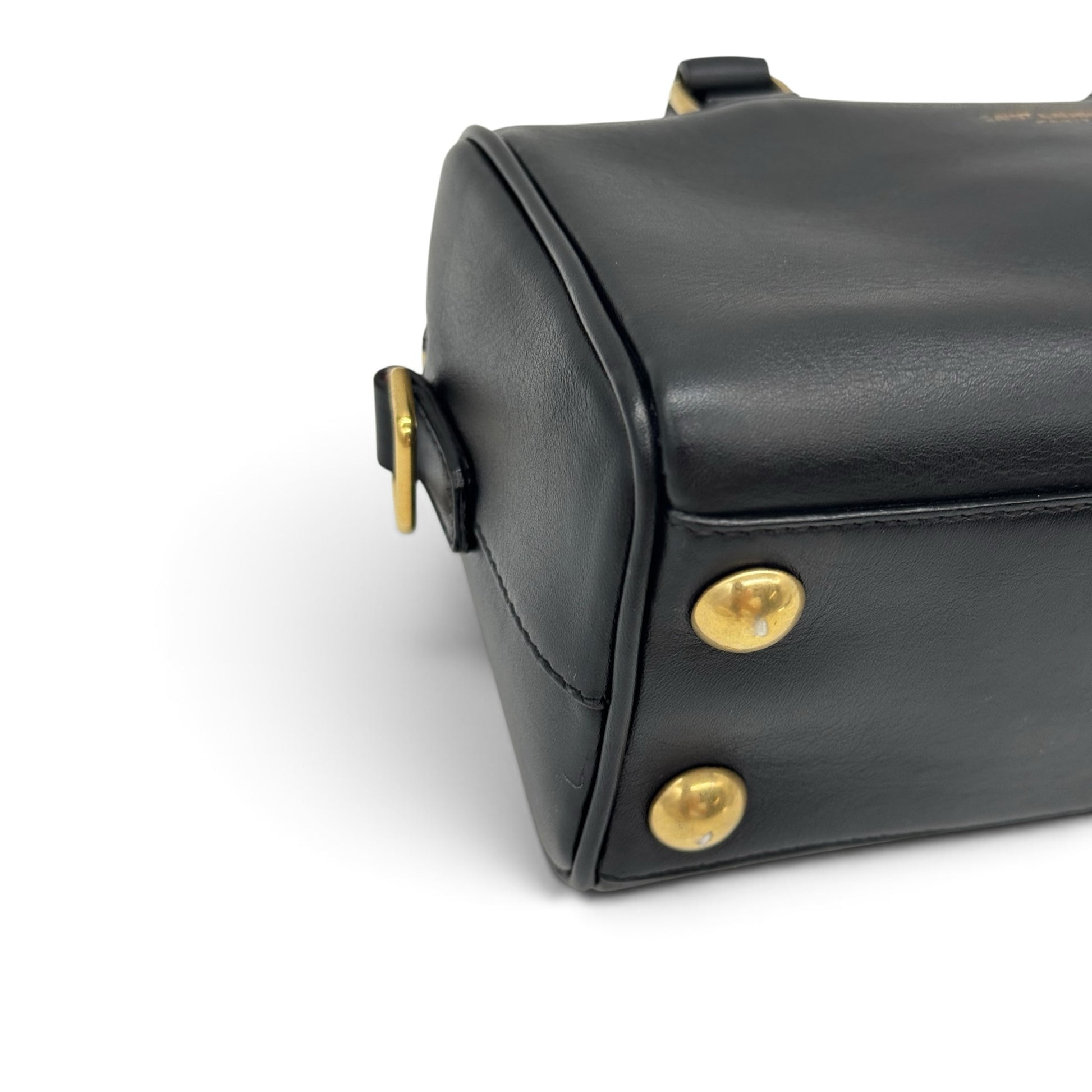 Dettaglio del fondo di una borsa a mano Borse Vintage Saint Laurent in pelle nera con piedini protettivi color oro