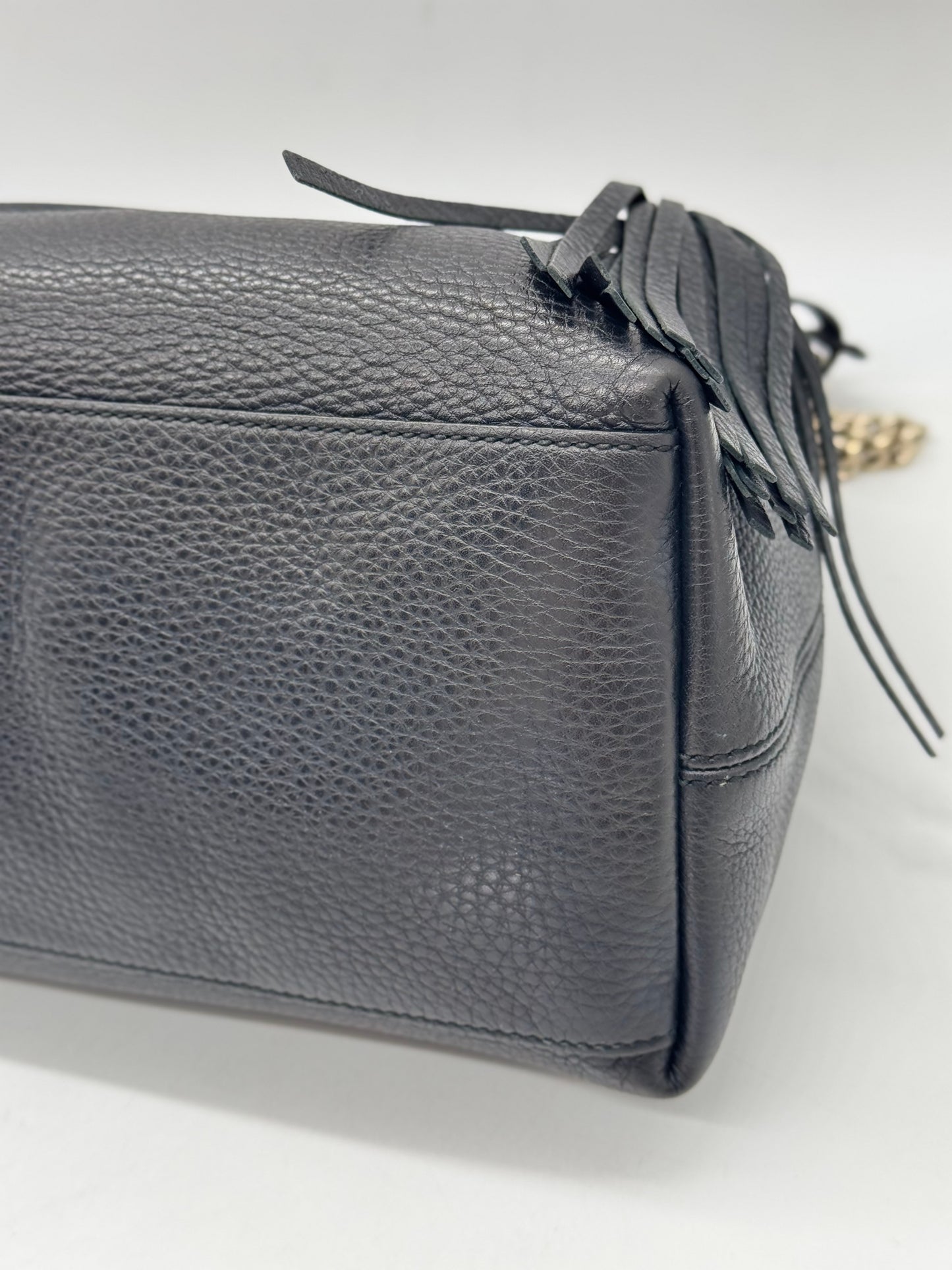 Dettaglio laterale della borsa a spalla Borse Vintage in pelle nera martellata con nappa decorativa e catena dorata