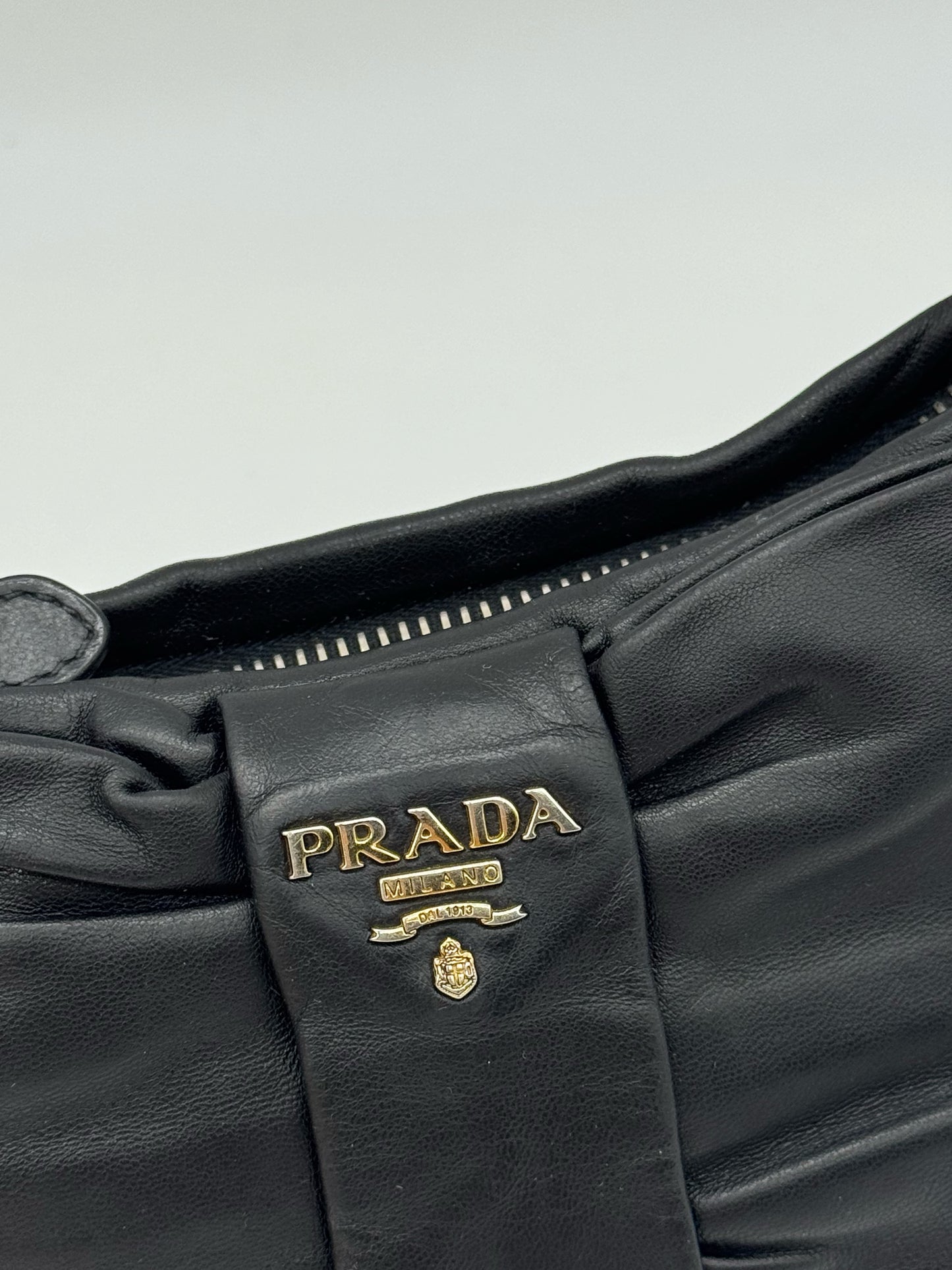 Dettaglio borsa a spalla Borse Vintage Prada in pelle nera con fiocco decorativo e logo in metallo dorato