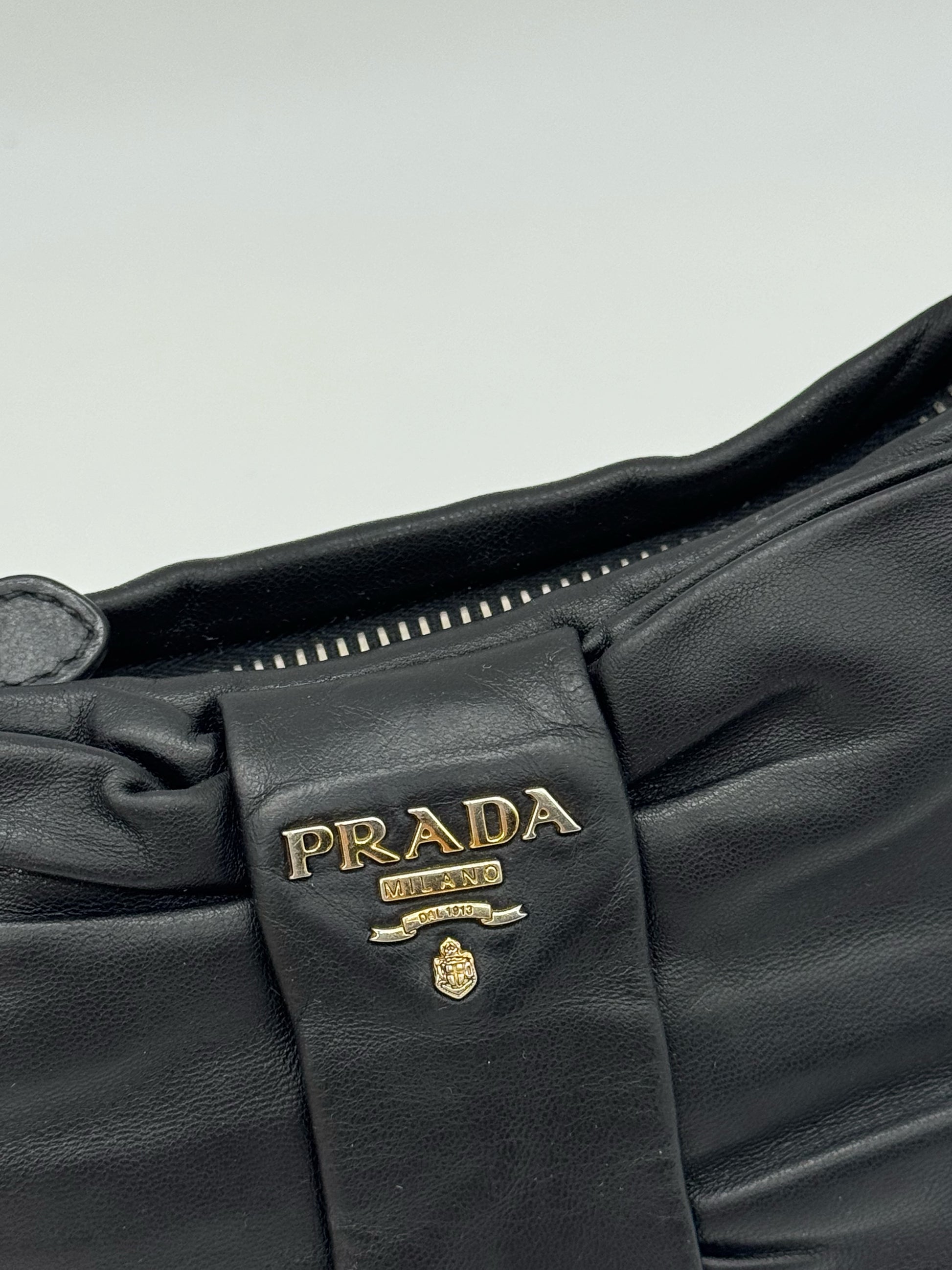 Dettaglio borsa a spalla Borse Vintage Prada in pelle nera con fiocco decorativo e logo in metallo dorato