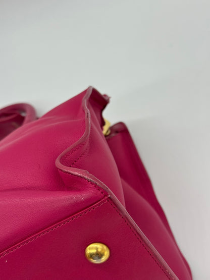 Dettaglio della borsa Borse Vintage Saint Laurent in pelle fucsia con piedini metallici dorati e cuciture precise
