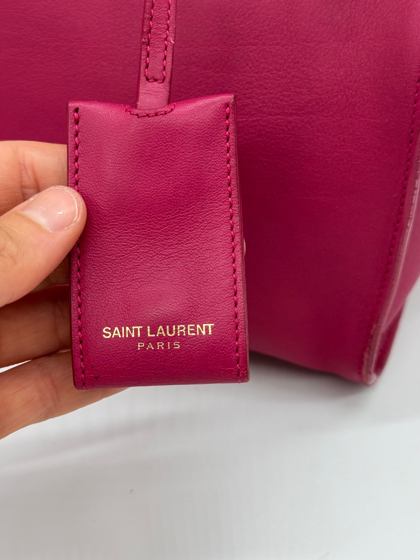 Dettaglio del cartellino in pelle fucsia con logo Saint Laurent Paris dorato su borsa Borse Vintage