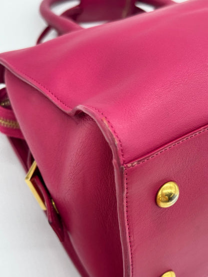 Dettaglio della base in pelle fucsia di una borsa Borse Vintage Saint Laurent con piedini protettivi dorati