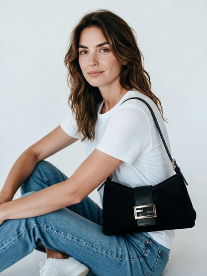 Modella indossa borsa a spalla Fendi Vintage nera in tessuto e pelle con fibbia metallica iconica su sfondo bianco
