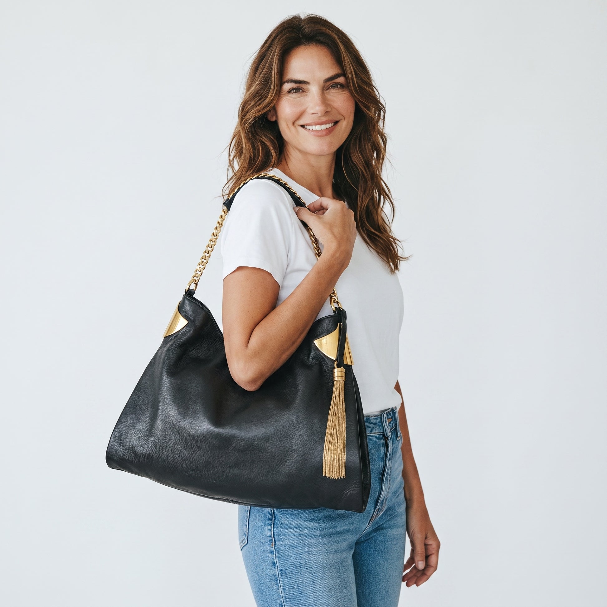 Modella sorridente indossa una borsa a spalla Borse Vintage Gucci in pelle nera con dettagli in metallo dorato