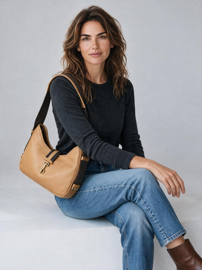 Modella indossa una borsa a spalla Borse Vintage in pelle color cuoio con chiusura a gancio dorata e tracolla tecnica