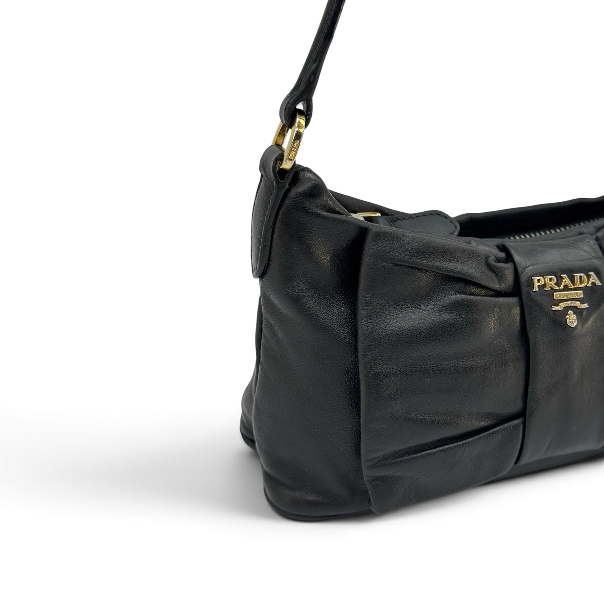 Borsa a spalla Borse Vintage Prada in pelle nera con dettaglio a fiocco e logo dorato, vista laterale.