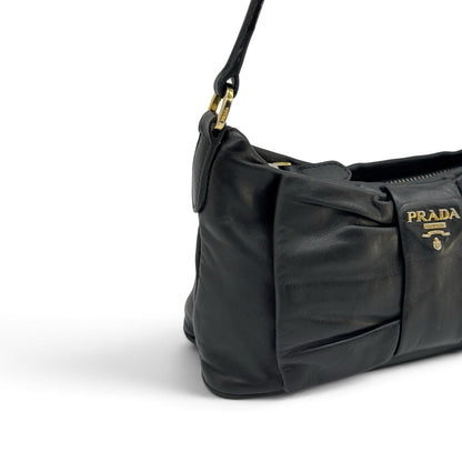 Borsa a spalla Borse Vintage Prada in pelle nera con dettaglio a fiocco e logo dorato, vista laterale.
