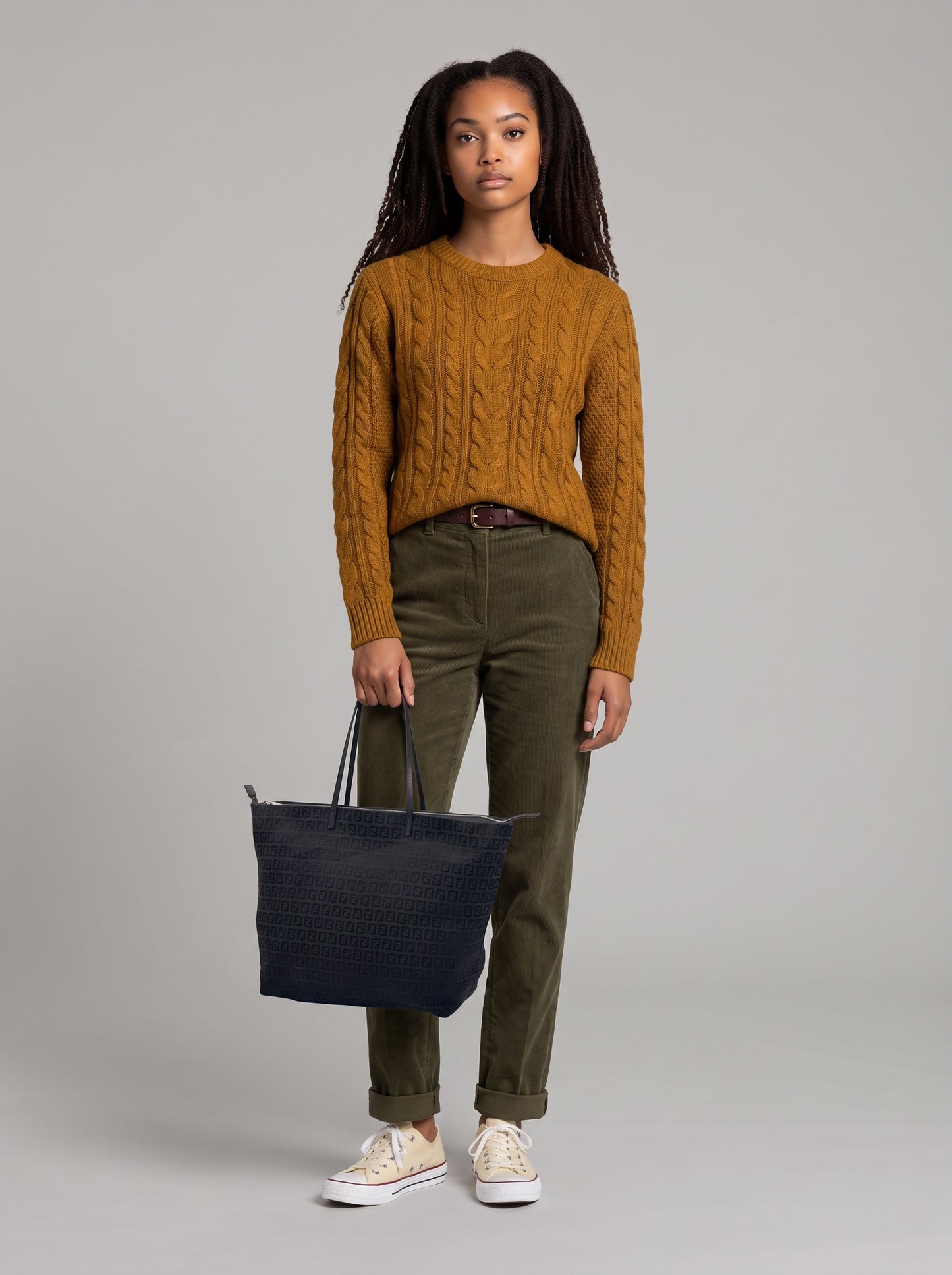 Modella che indossa una borsa tote Fendi nera con motivo FF jacquard, proposta da Borse Vintage