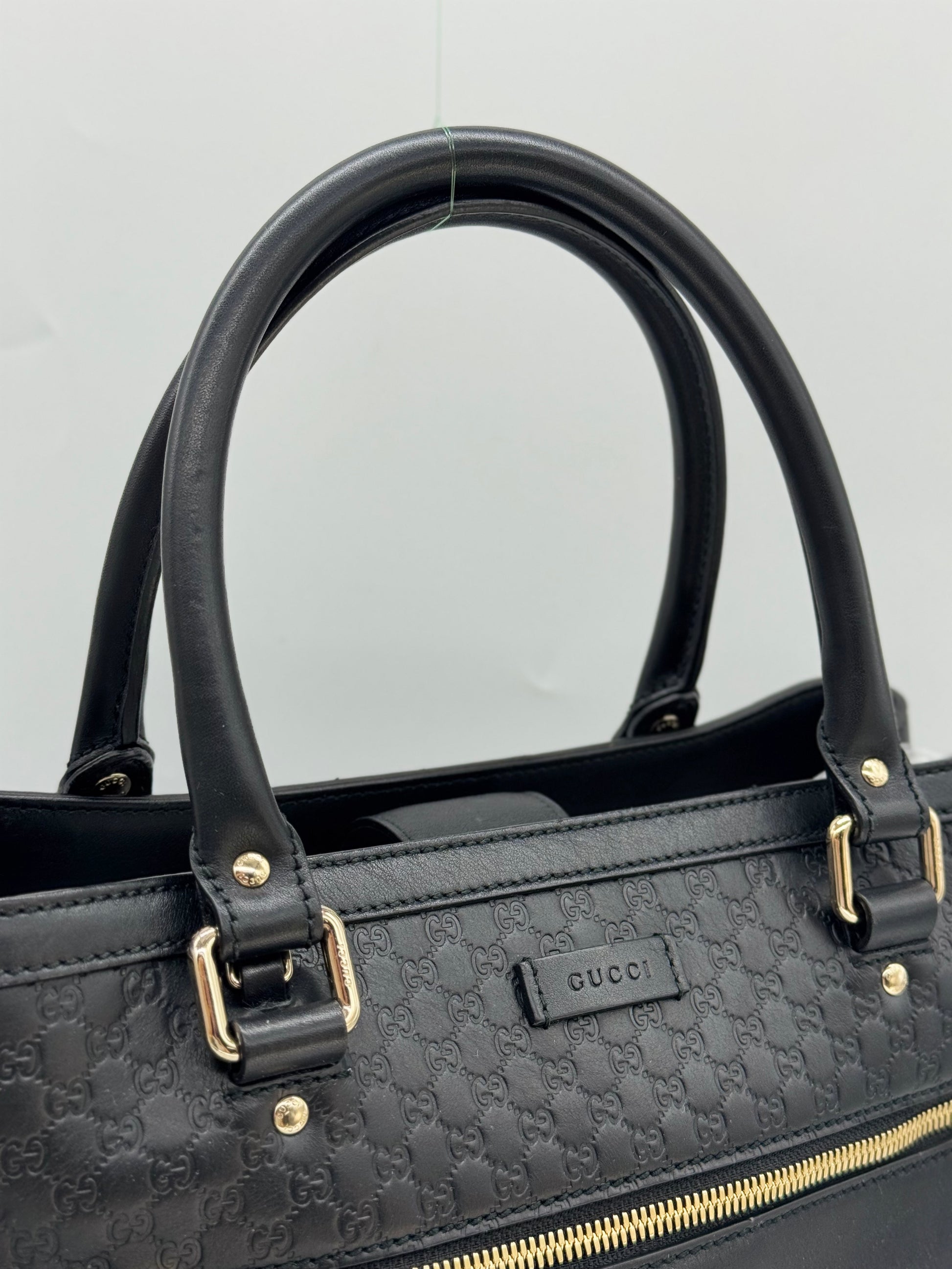 Borsa tote Borse Vintage Gucci in pelle nera con motivo GG impresso, manici in pelle e dettagli in metallo dorato.