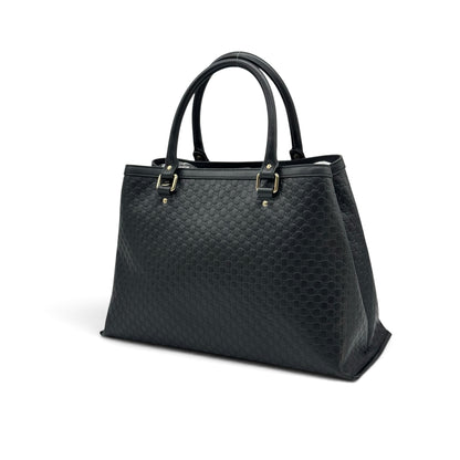 Borsa tote Borse Vintage Gucci in pelle nera con motivo GG impresso e dettagli in metallo dorato su sfondo bianco