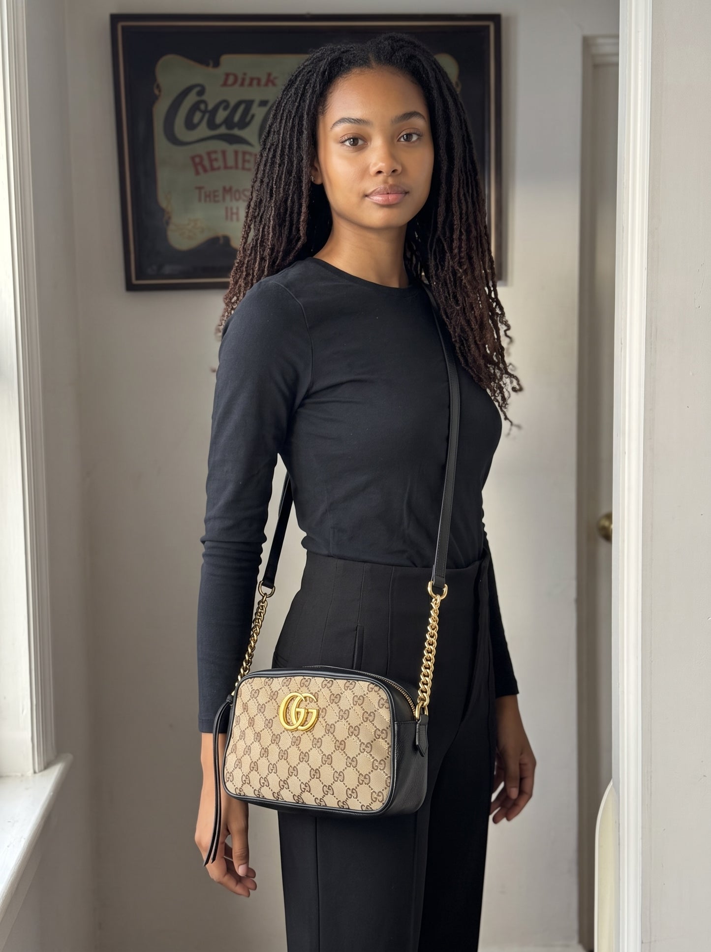 Modella indossa borsa a tracolla Borse Vintage Gucci Marmont in tela GG Supreme e pelle nera con logo dorato