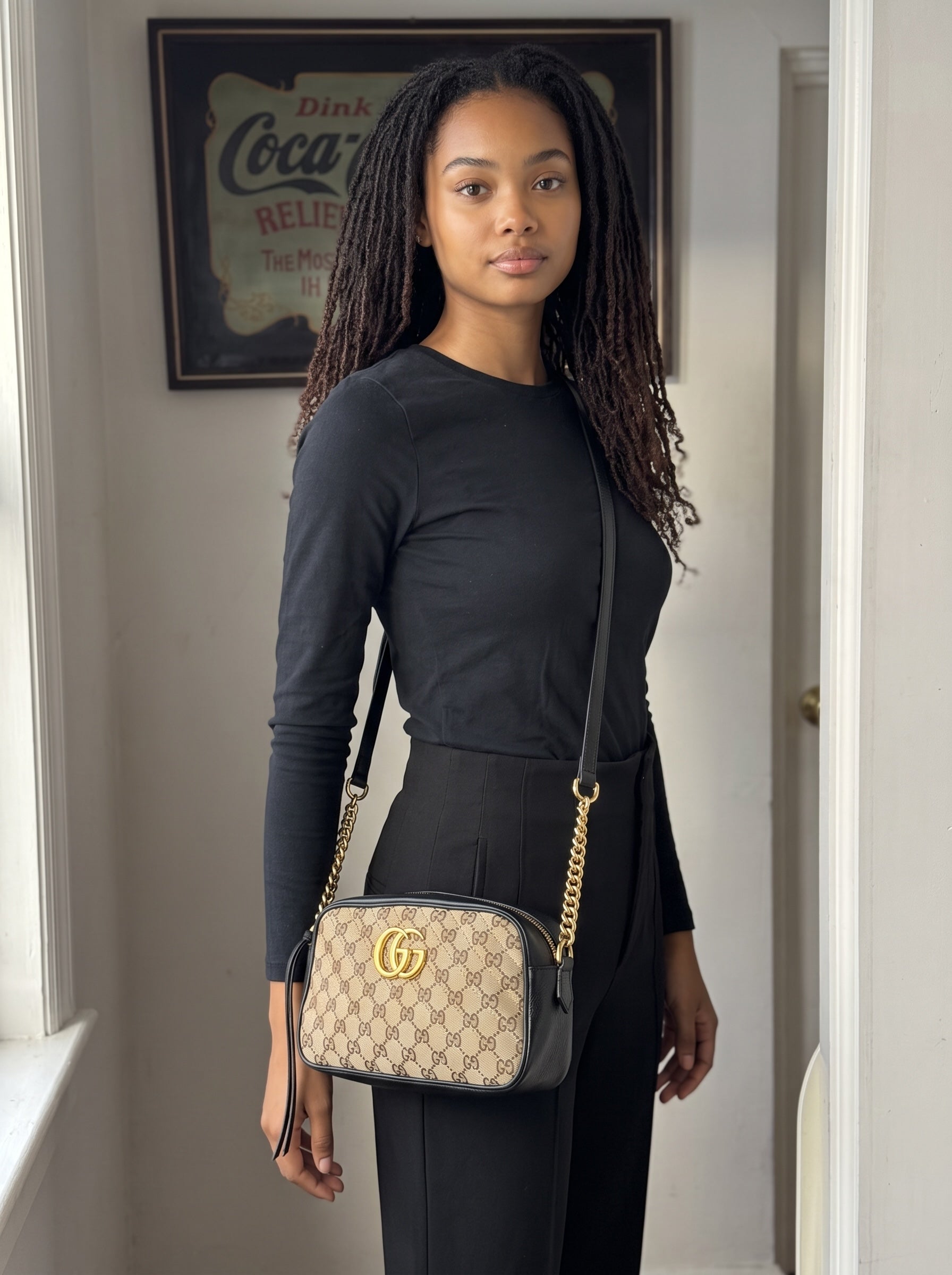 Modella indossa borsa a tracolla Borse Vintage Gucci Marmont in tela GG Supreme e pelle nera con logo dorato