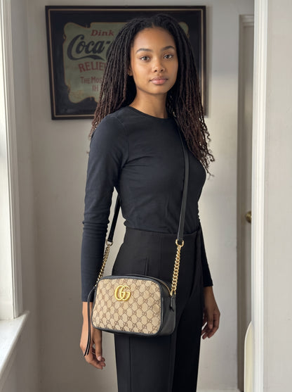 Modella indossa borsa a tracolla Borse Vintage Gucci Marmont in tela GG Supreme e pelle nera con logo dorato