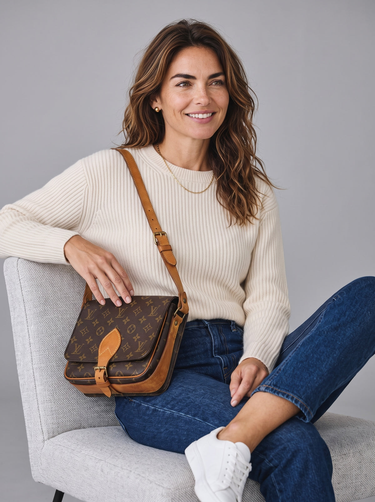 Modella sorridente indossa una borsa a tracolla Borse Vintage Louis Vuitton in tela Monogram con dettagli in pelle