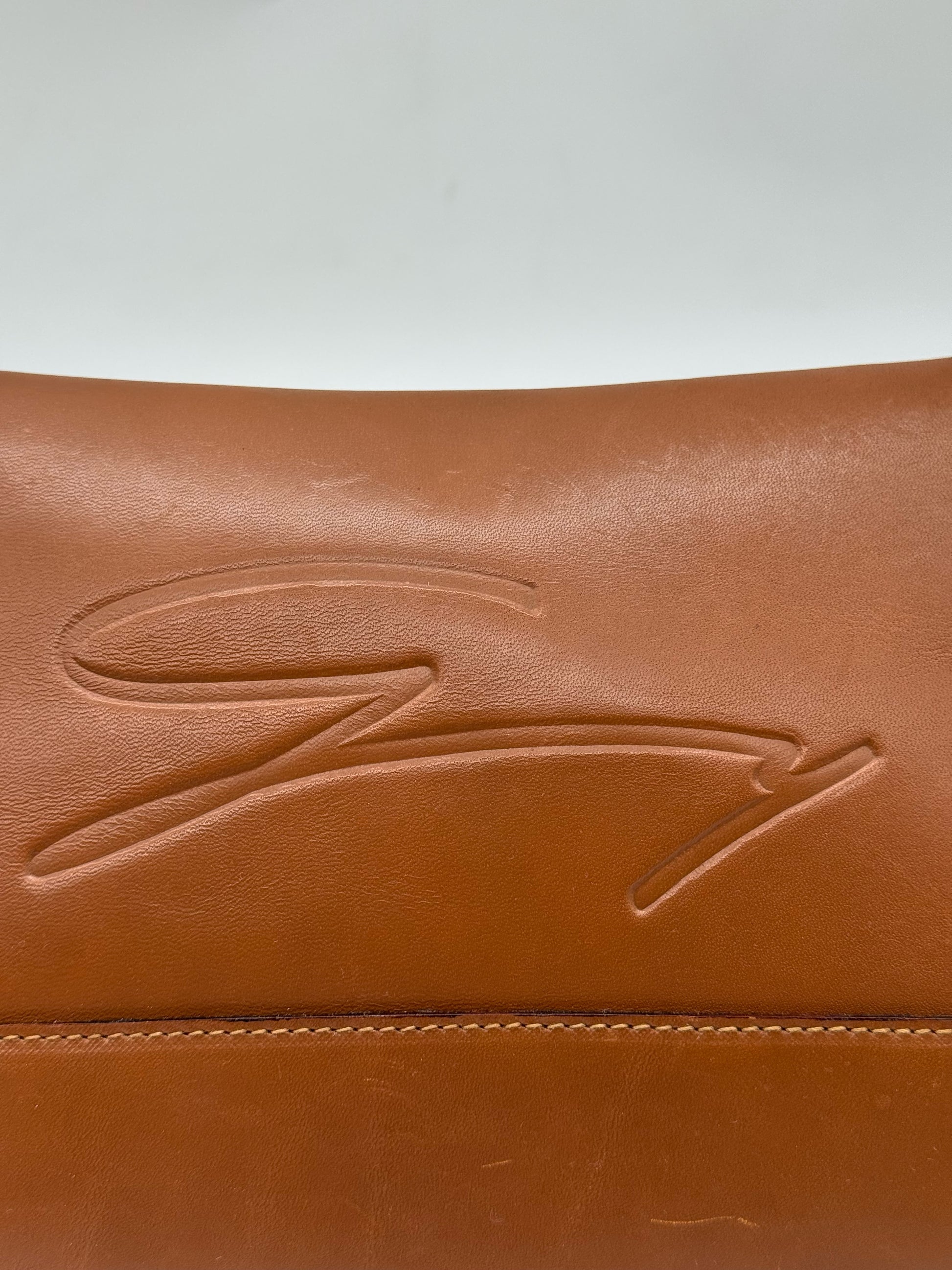Dettaglio del logo impresso su borsa a tracolla Borse Vintage in pelle color cuoio con cuciture a vista