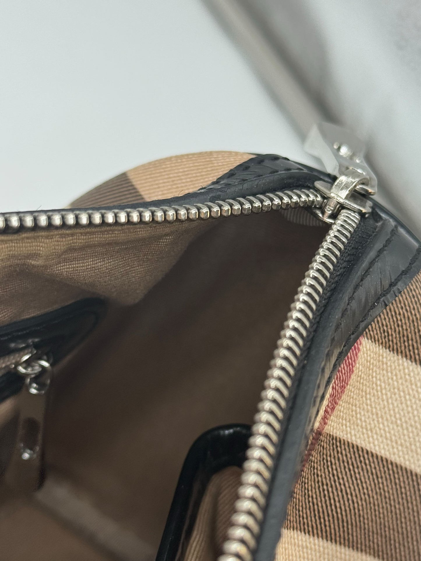 Dettaglio della chiusura a zip in metallo argentato della borsa Borse Vintage Burberry con motivo check e vernice nera