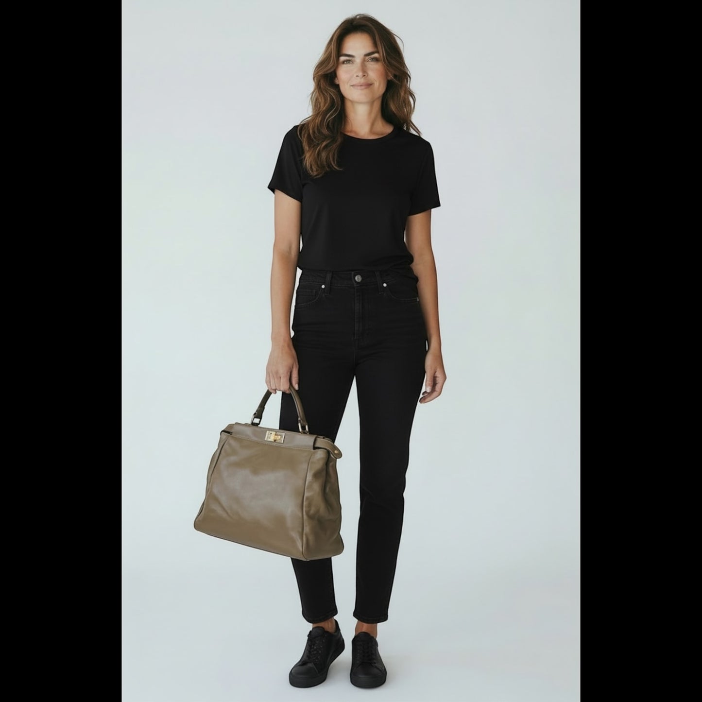 Modella che indossa un outfit nero con borsa a mano FENDI Peekaboo in pelle color tortora di Borse Vintage