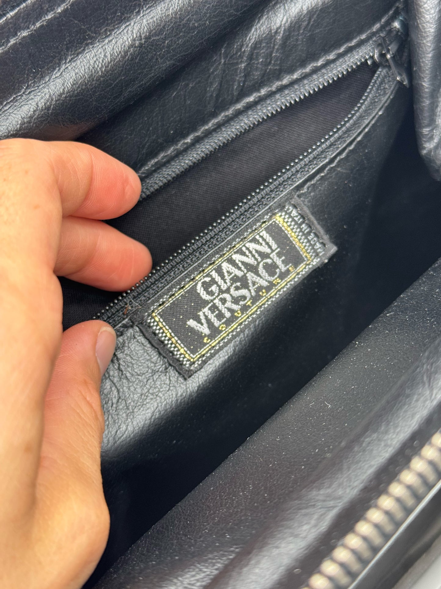 Interno di una borsa a mano Borse Vintage Gianni Versace in pelle nera con etichetta del brand e tasca con zip