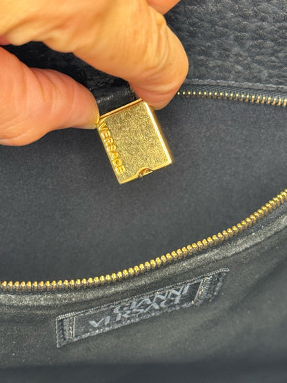 Dettaglio interno della borsa Borse Vintage Gianni Versace con cerniera dorata e logo inciso su tiralampo