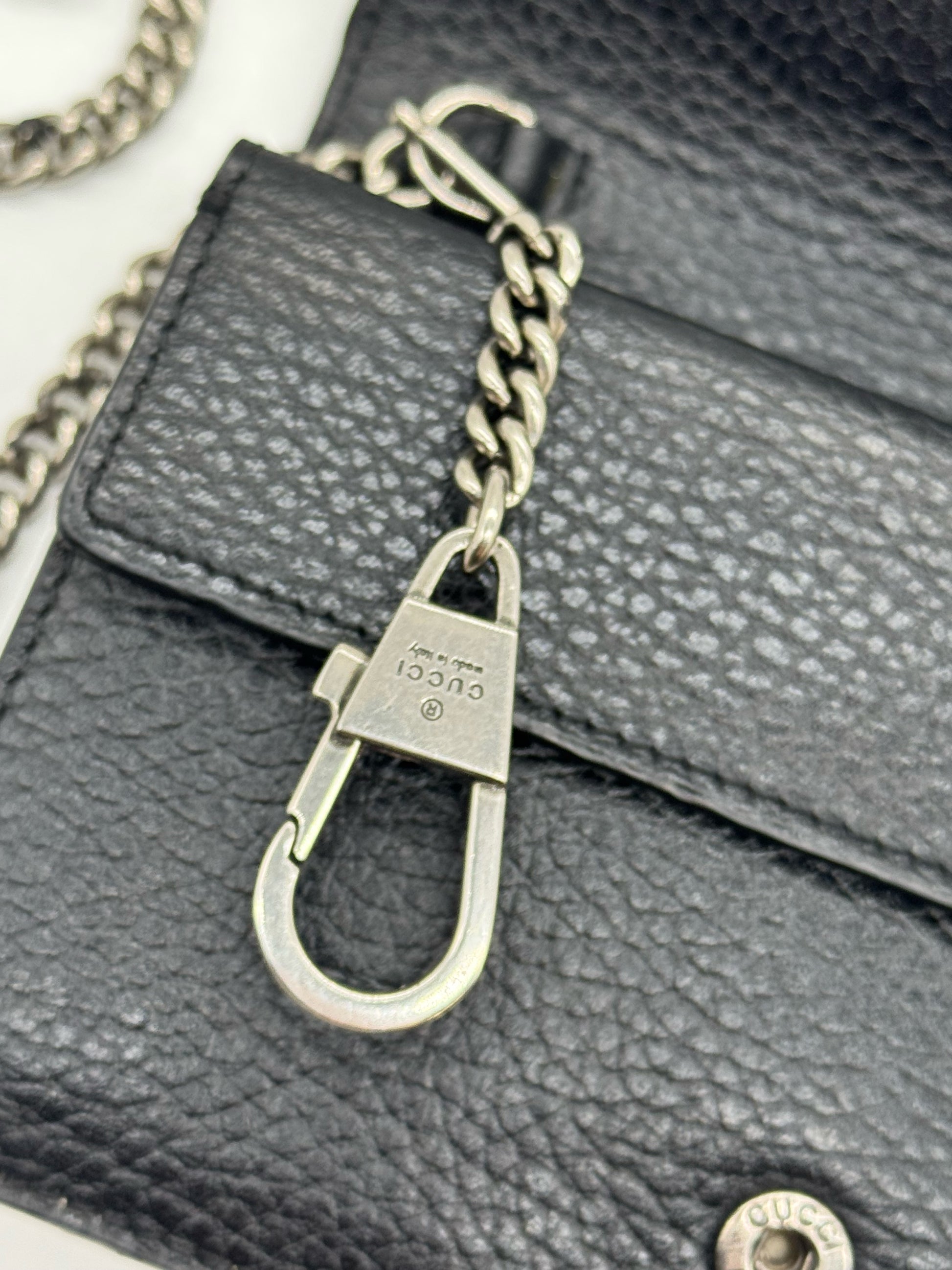 Dettaglio del moschettone in metallo argentato con logo Gucci su borsa Borse Vintage in pelle nera martellata