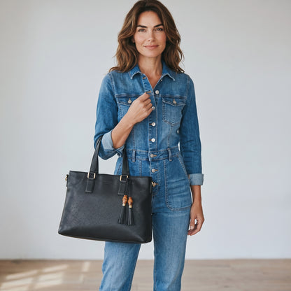 Donna con tuta in denim che indossa una borsa tote Borse Vintage Gucci in pelle nera martellata con dettagli in bambù