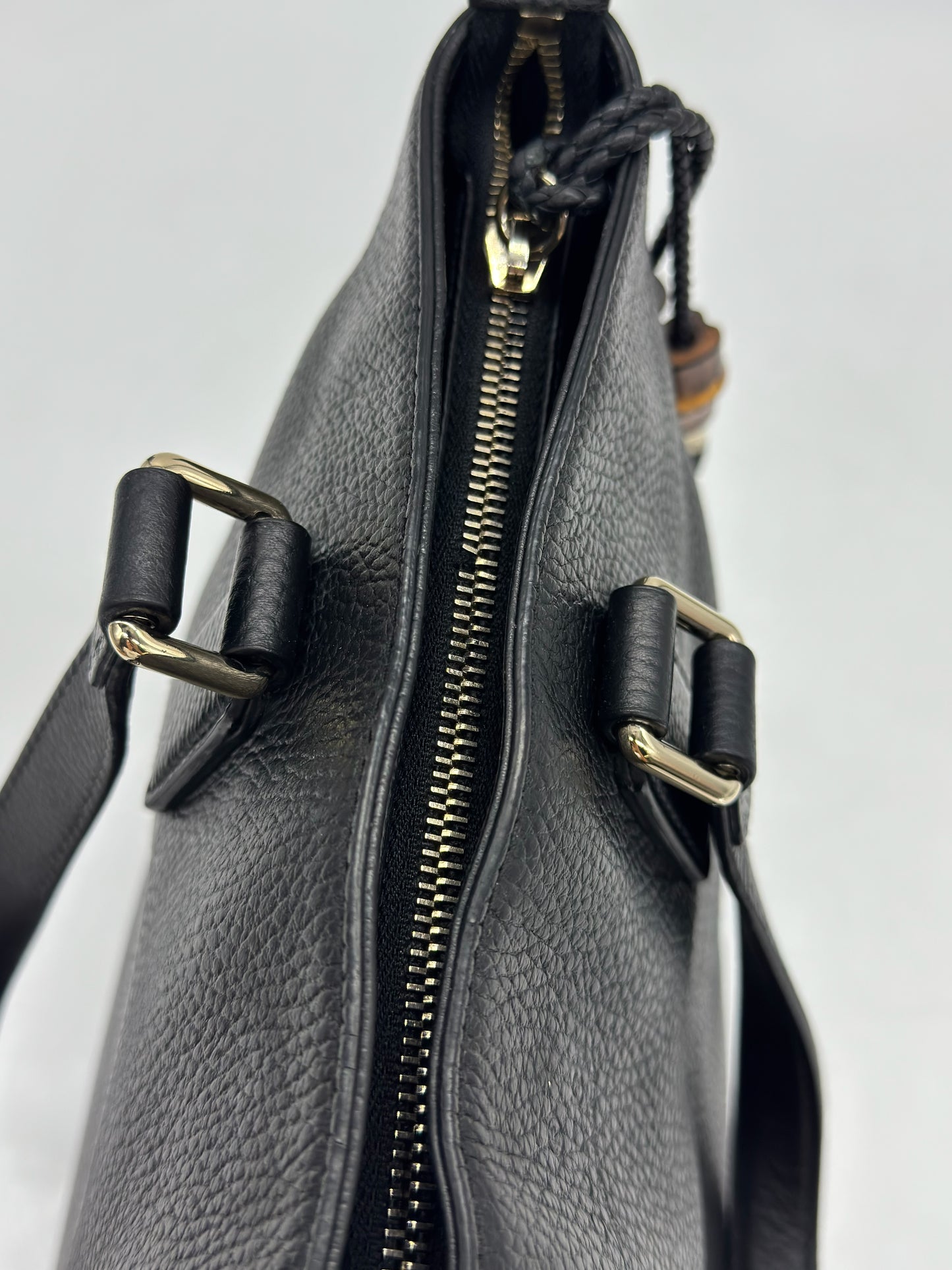 Dettaglio della chiusura a zip superiore di una borsa tote Borse Vintage Gucci in pelle nera martellata con finiture dorate