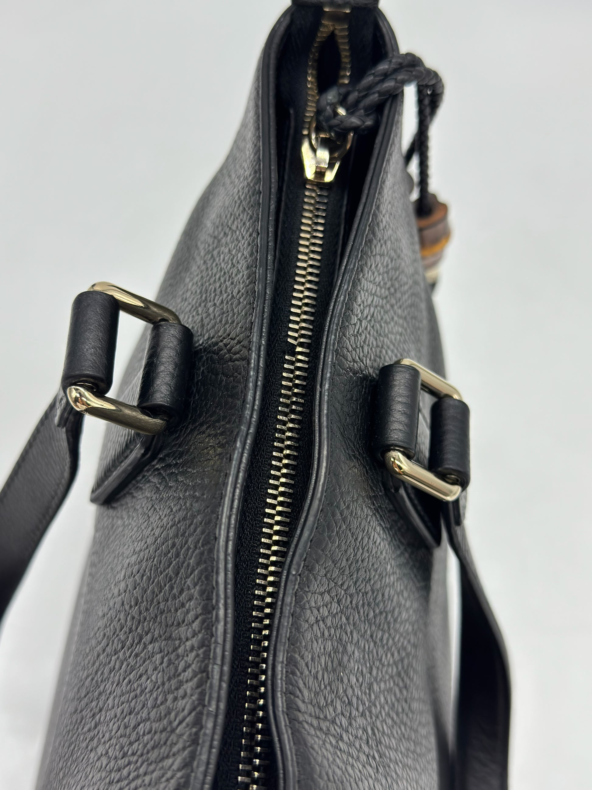 Dettaglio della chiusura a zip superiore di una borsa tote Borse Vintage Gucci in pelle nera martellata con finiture dorate