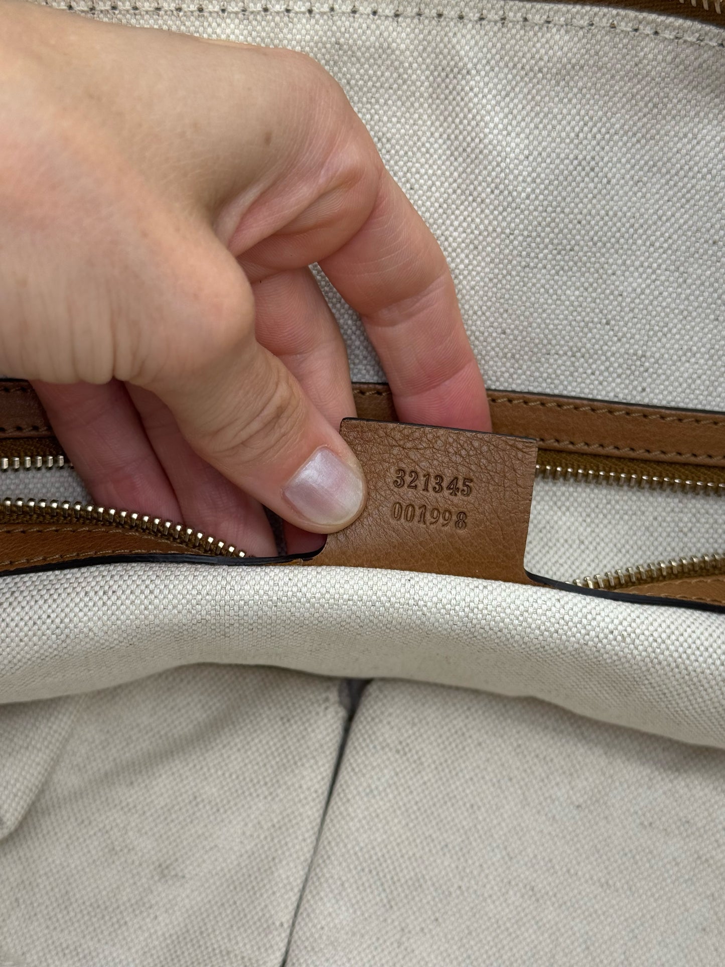Dettaglio interno di borsa Borse Vintage Gucci con etichetta in pelle e codice di autenticità impresso