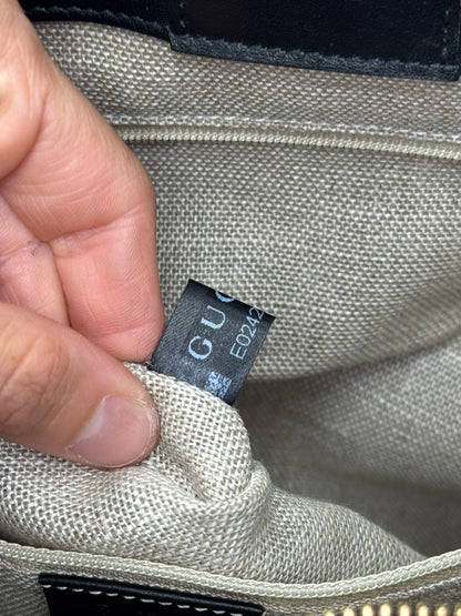 Etichetta interna di autenticità Borse Vintage su borsa tote Gucci in pelle nera con codice seriale visibile