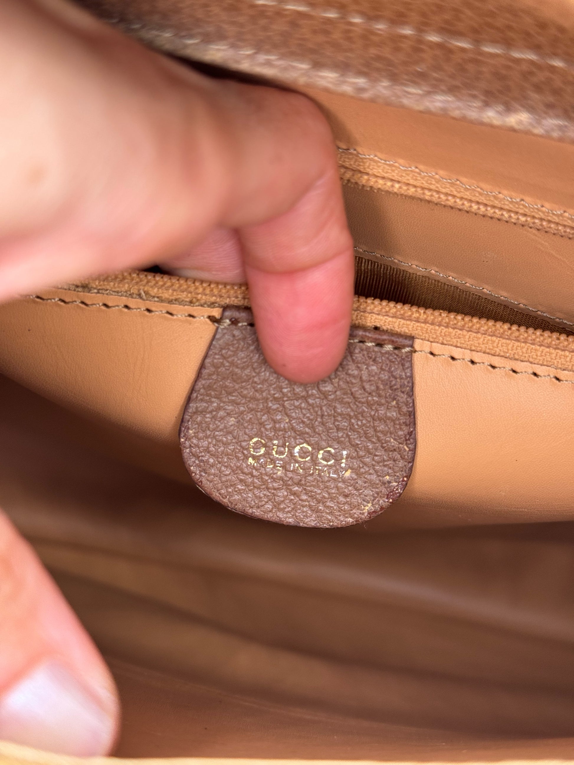 Dettaglio interno della borsa Borse Vintage Gucci con etichetta in pelle marrone e logo impresso Made in Italy