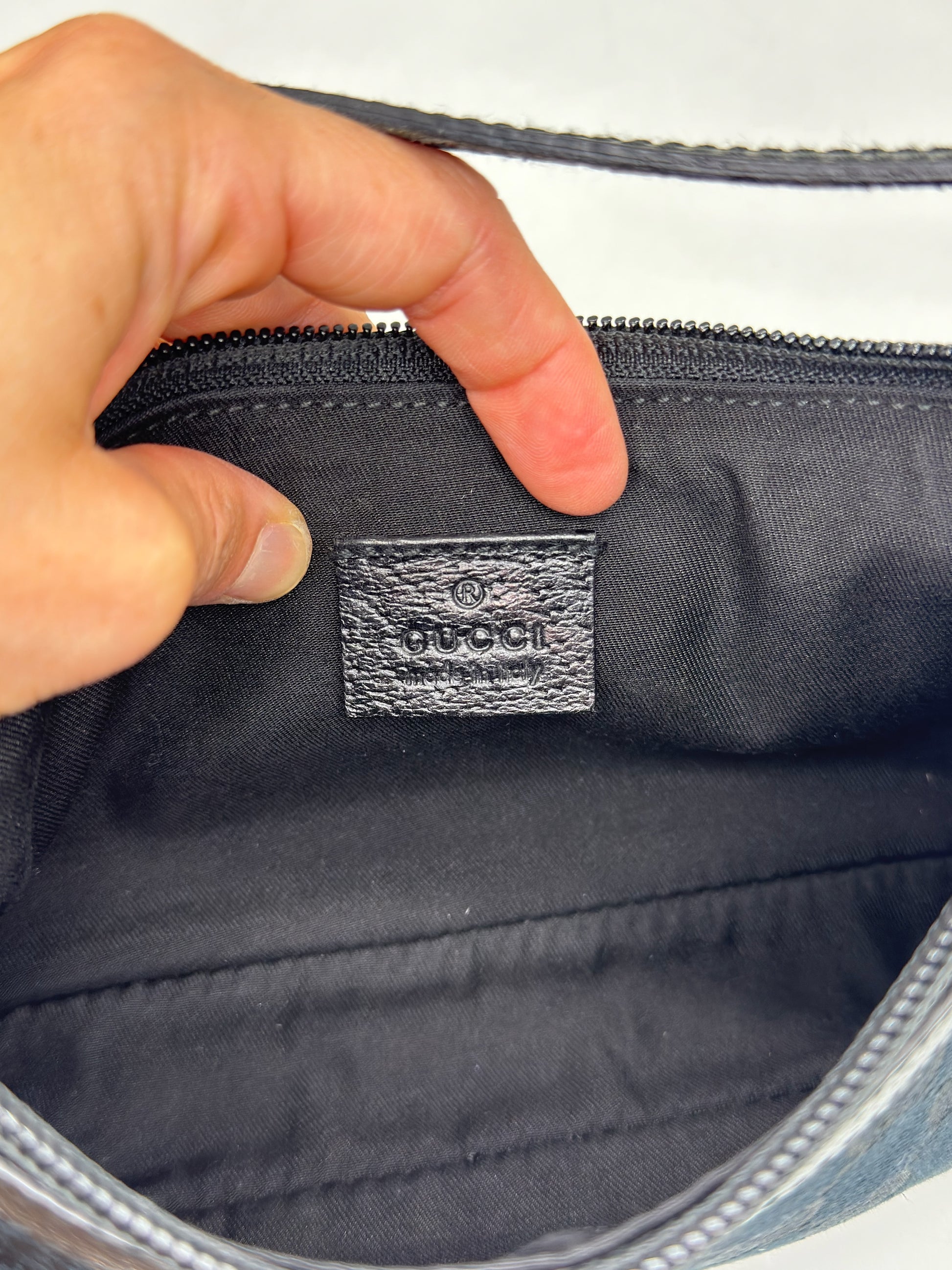 Dettaglio interno della borsa a spalla Borse Vintage Gucci con etichetta in pelle nera e logo impresso