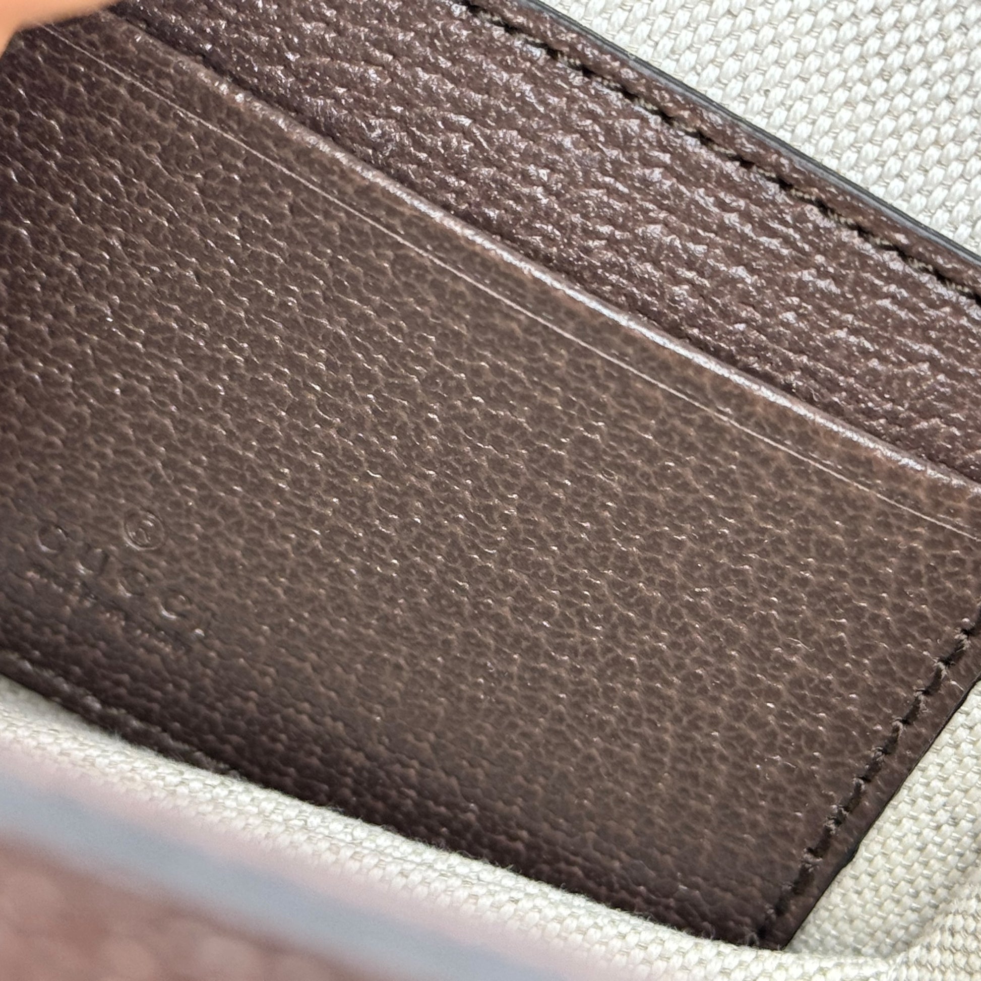 Dettaglio interno della borsa Borse Vintage Gucci con etichetta in pelle marrone goffrata e fodera in tessuto chiaro