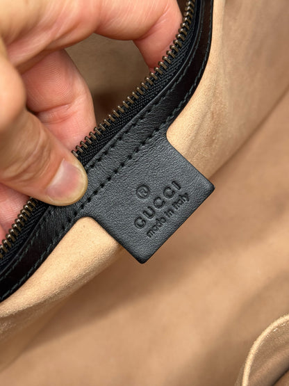 Etichetta interna in pelle nera con logo Gucci impresso all'interno di una borsa Borse Vintage