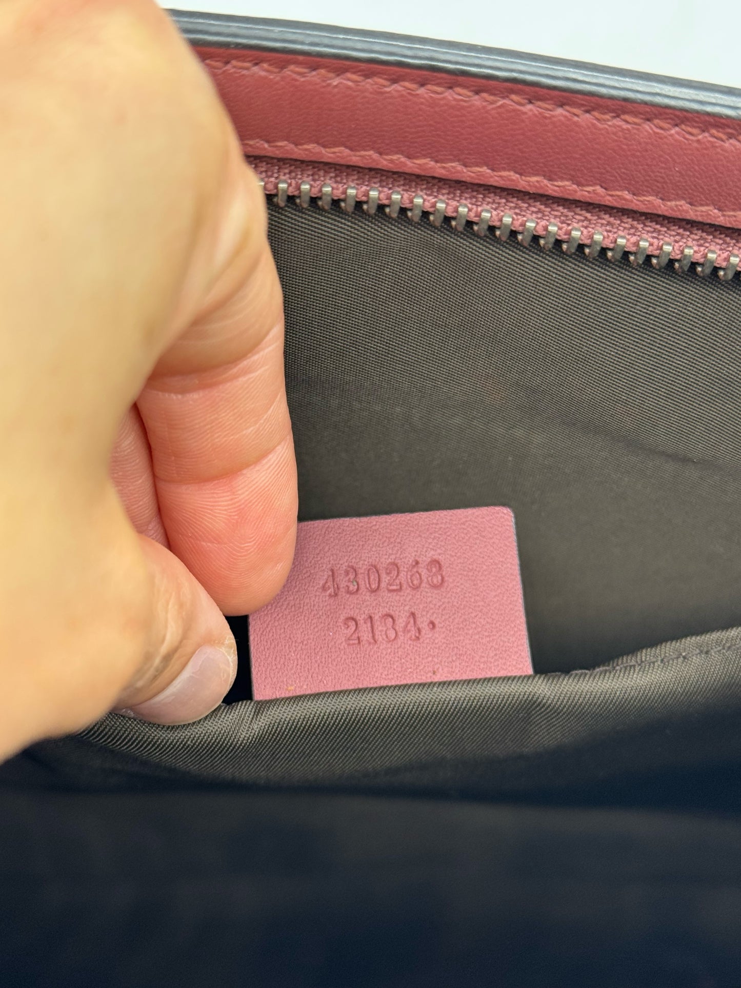 Etichetta interna in pelle bordeaux con codice seriale di una pochette Borse Vintage Gucci in tela
