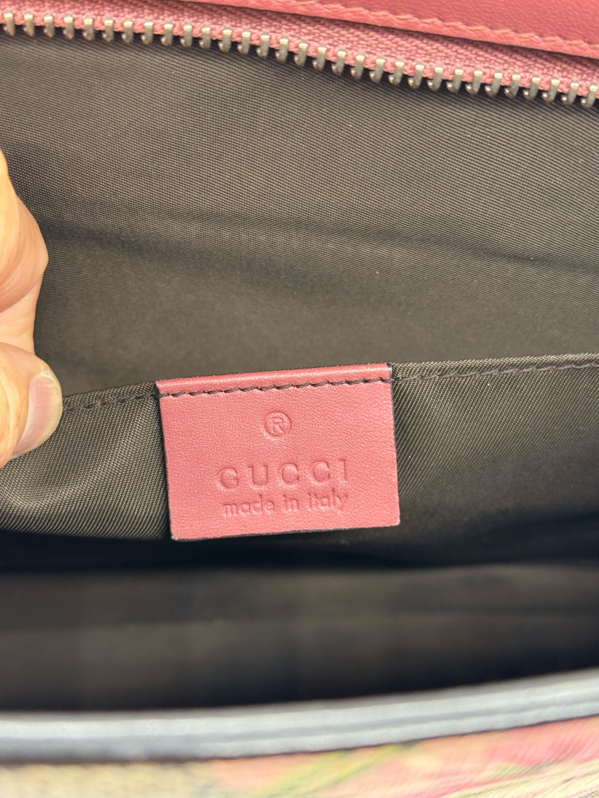Etichetta interna in pelle bordeaux con logo Gucci impressa all'interno di una pochette Borse Vintage