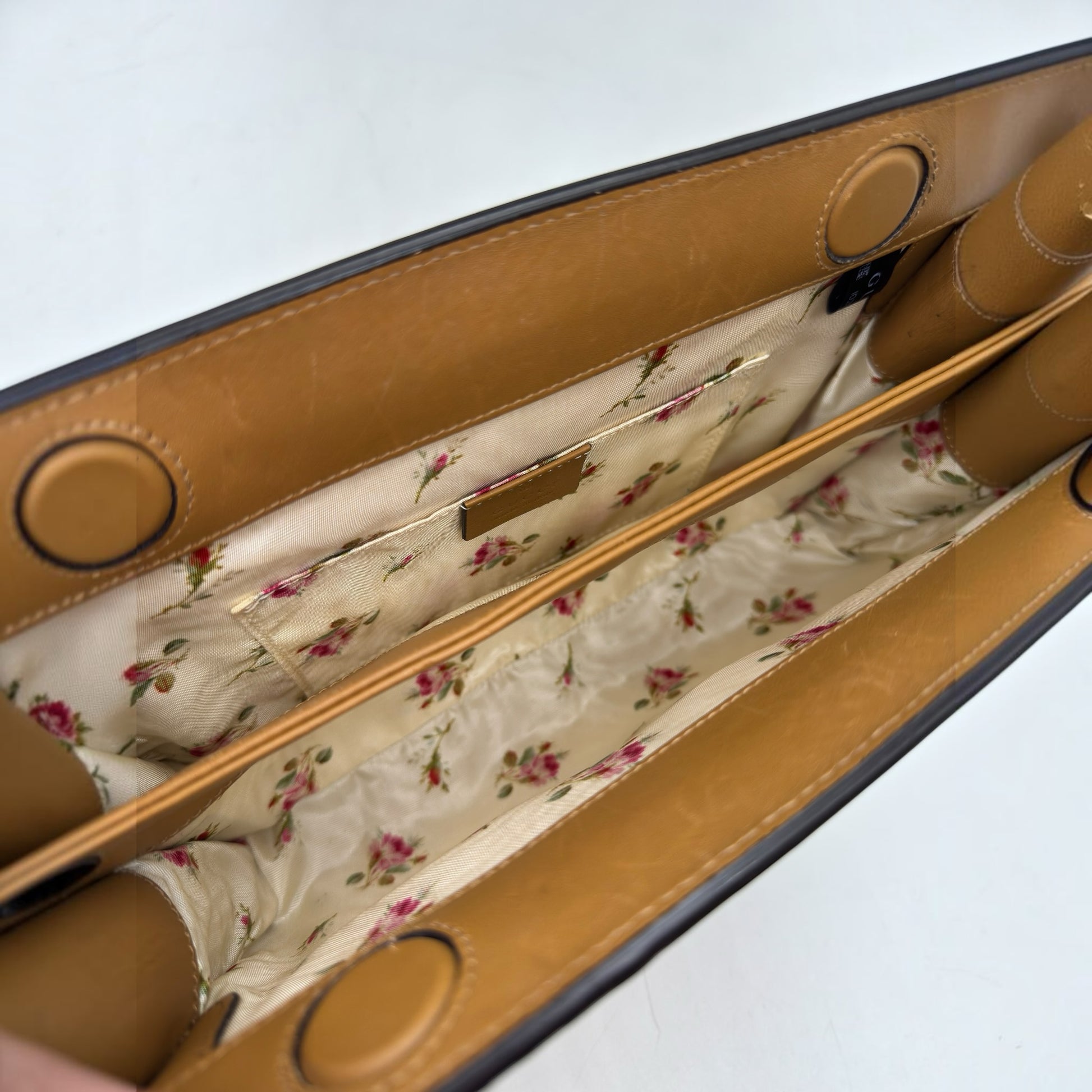 Interno di una borsa Borse Vintage Gucci con fodera in tessuto a stampa floreale e scomparti in pelle color cuoio