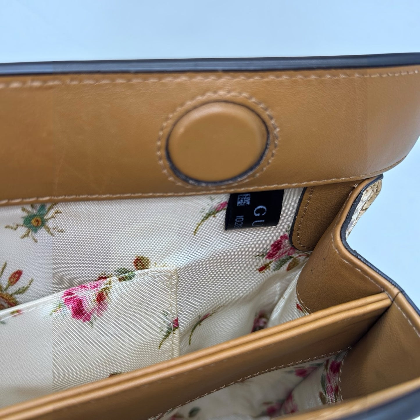 Interno di una borsa Borse Vintage Gucci con fodera in tessuto a motivo floreale e dettagli in pelle marrone